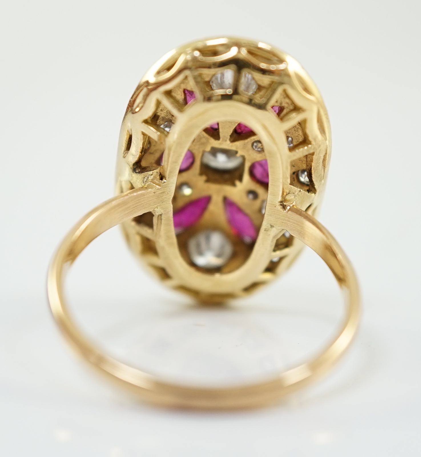 A modern gold, ruby and diamond set oval cluster ring